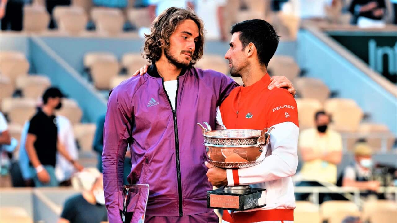 Novak Djokovic, right, and Stefanos Tsitsipas hug while holding their trophies after their final match of the French Open tennis tournament Roland Garros.
