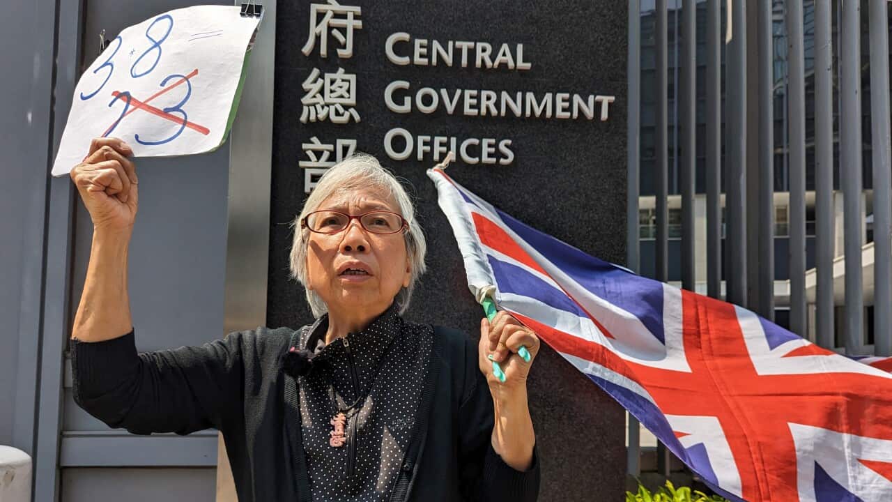 A woman hold up a Union Jack flag in protest