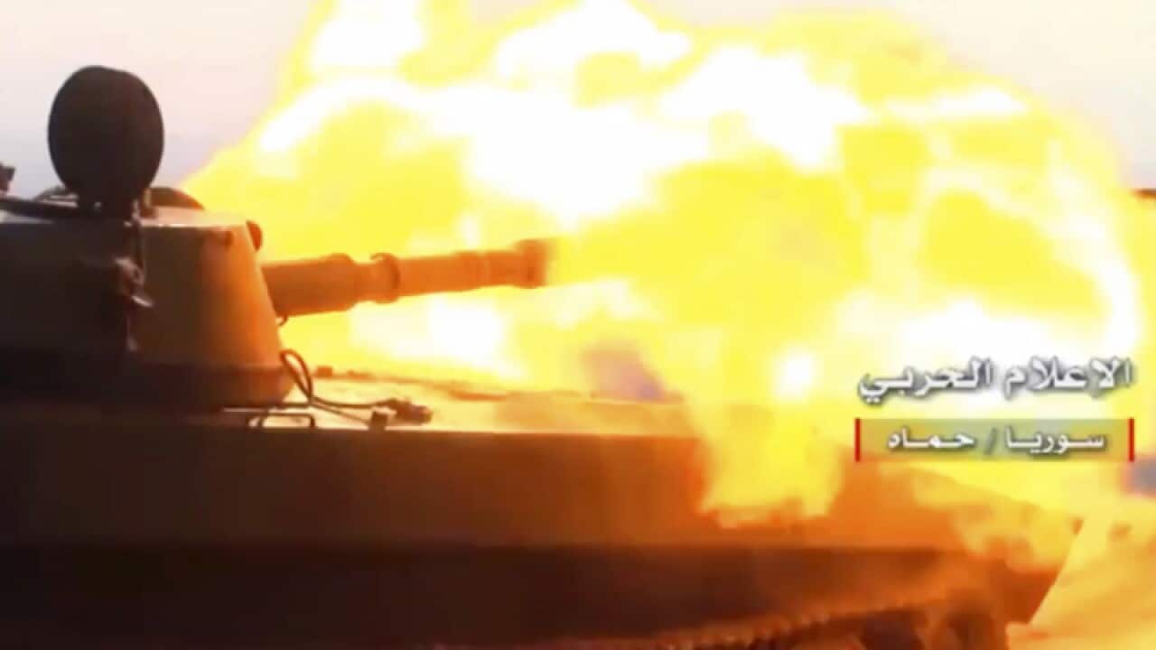 A Syrian forces tank fires at insurgent positions near Hama, Syria