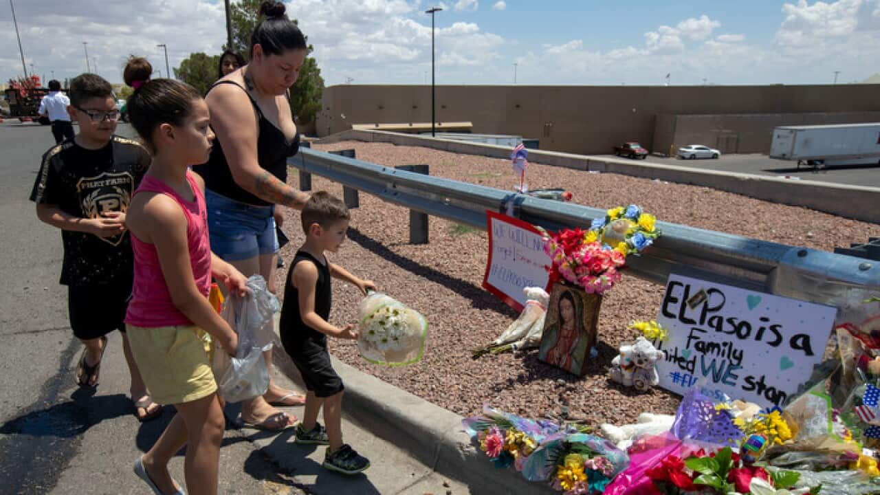 An El Paso family bring flowers to the makeshift memorial for the victims of Saturday mass shooting at a shopping complex in El Paso, Texas