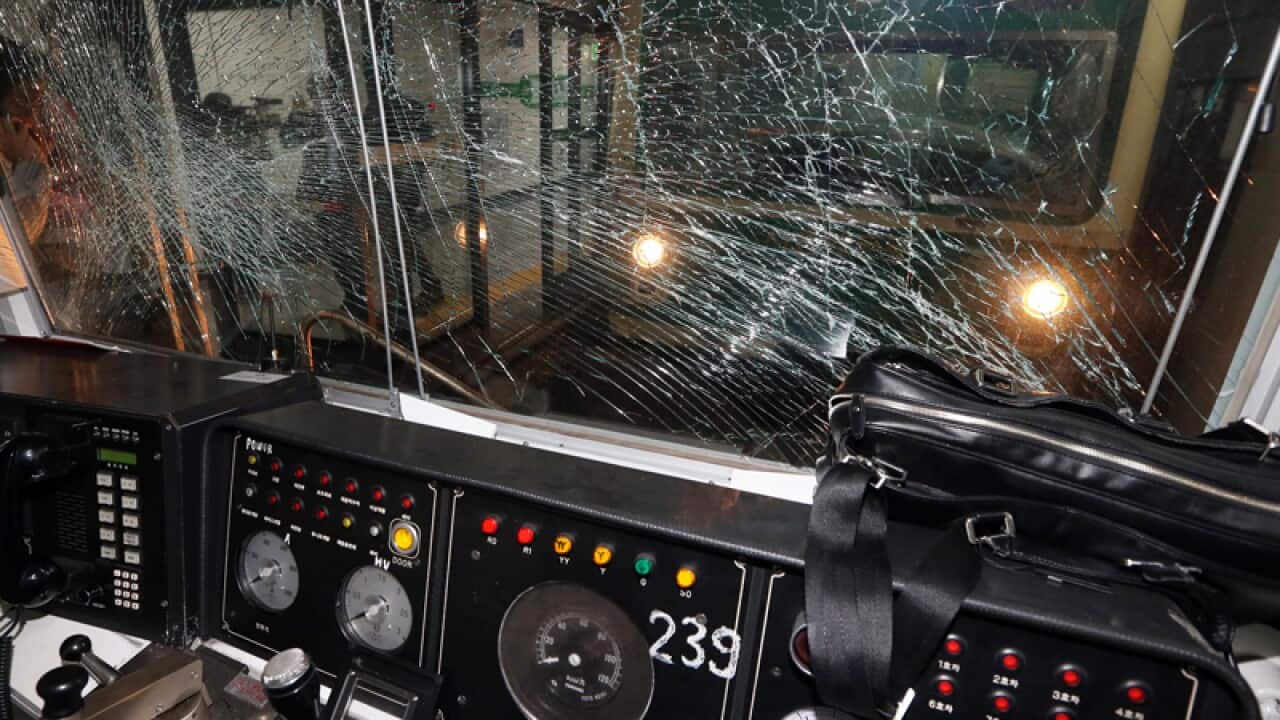 A window of a subway train is broken after a collision.