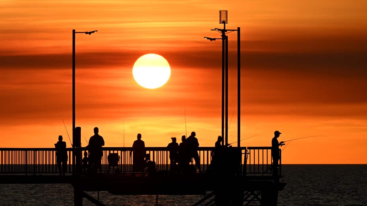People are seen fishing on the Nightcliff Jetty as the sunsets in the suburb of Nightcliff in Darwin.
