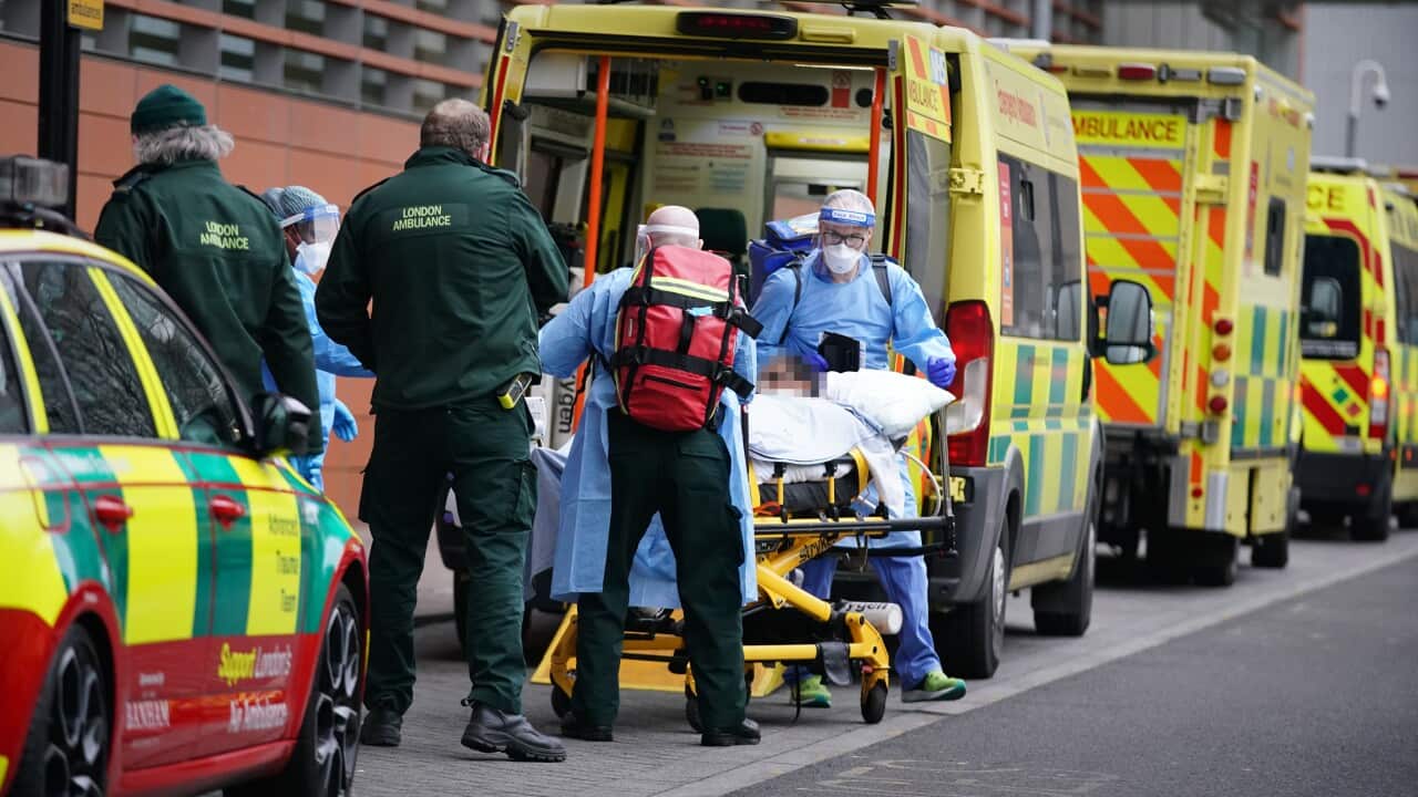 Paramedics transfer a patient from an ambulance into the Royal London Hospital
