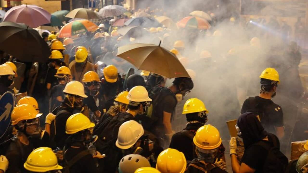 Anti-extradition bill protesters stand surrounded by tear gas smoke fired by riot police during a rally against the police brutality in Hong Kong, China.