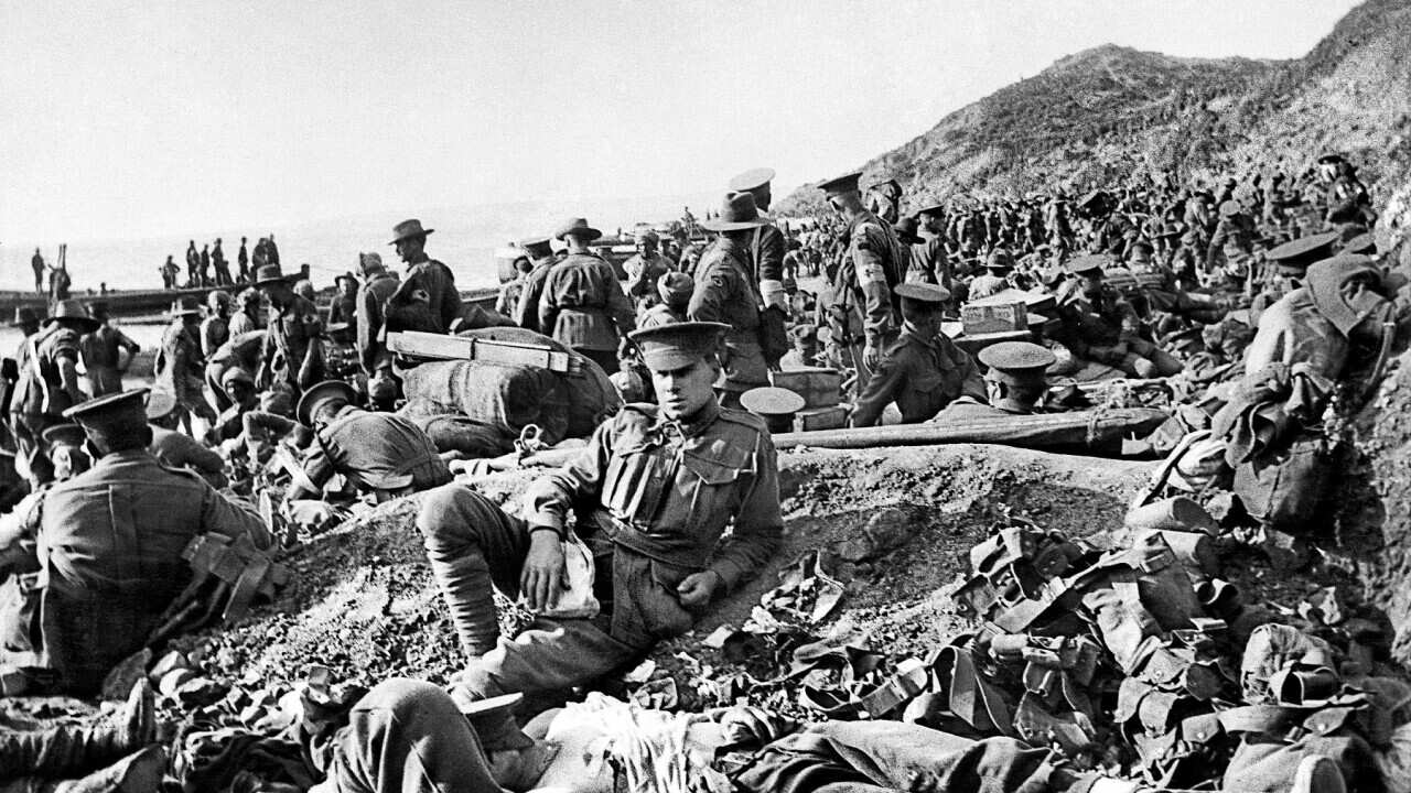 An Australian soldier lies wounded, as other soldiers move on the beach at Anzac Cove on the day of the landing. (Getty)