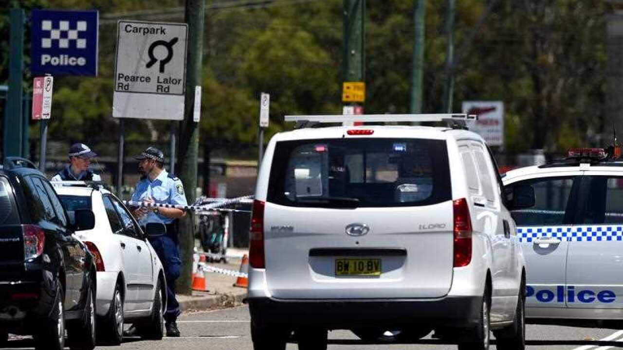 Police officers stand outside of the Quakers Hill Police Station in Sydney.