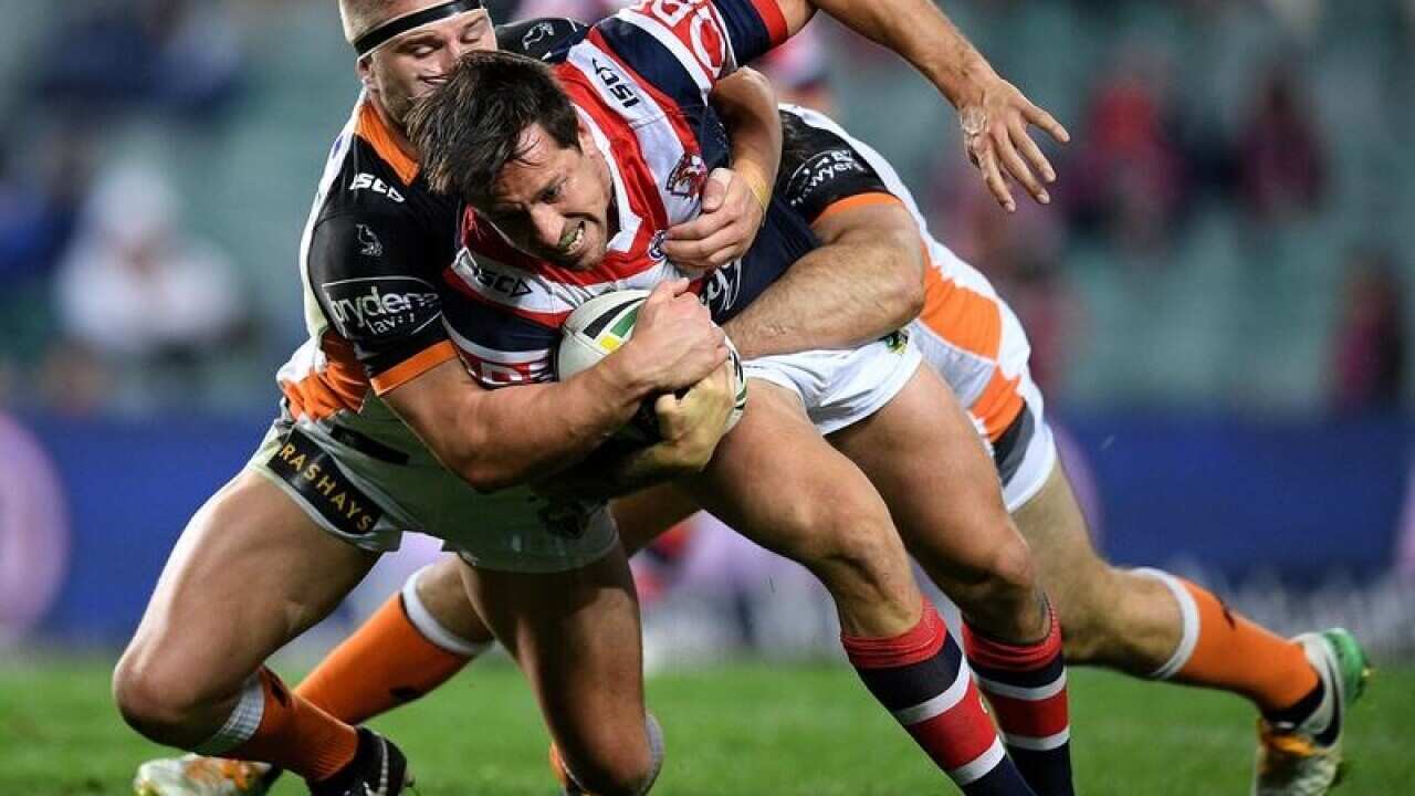 Mitchell Pearce of the Roosters is tackled by Matthew McIlwrick.