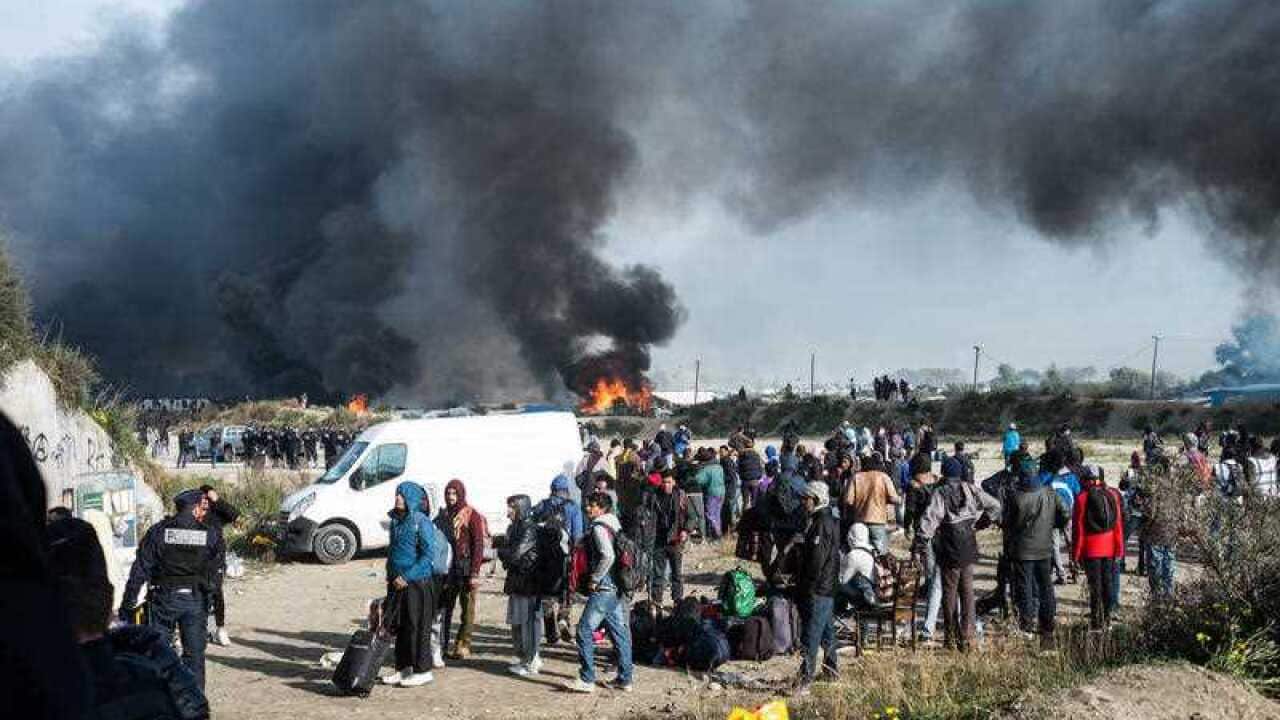 Smoke rises from the Jungle, the makeshift migrant camp of Calais on October 26, 2016 