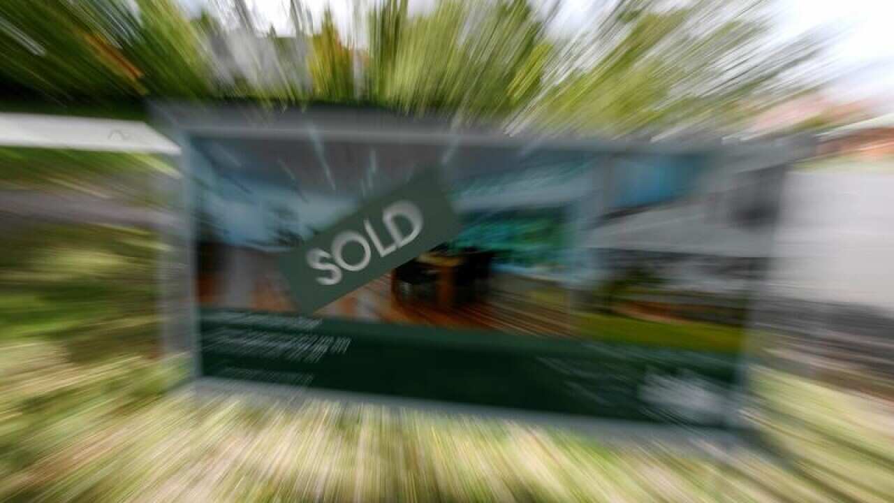 A file image of a real estate advertising board with a Sold sign