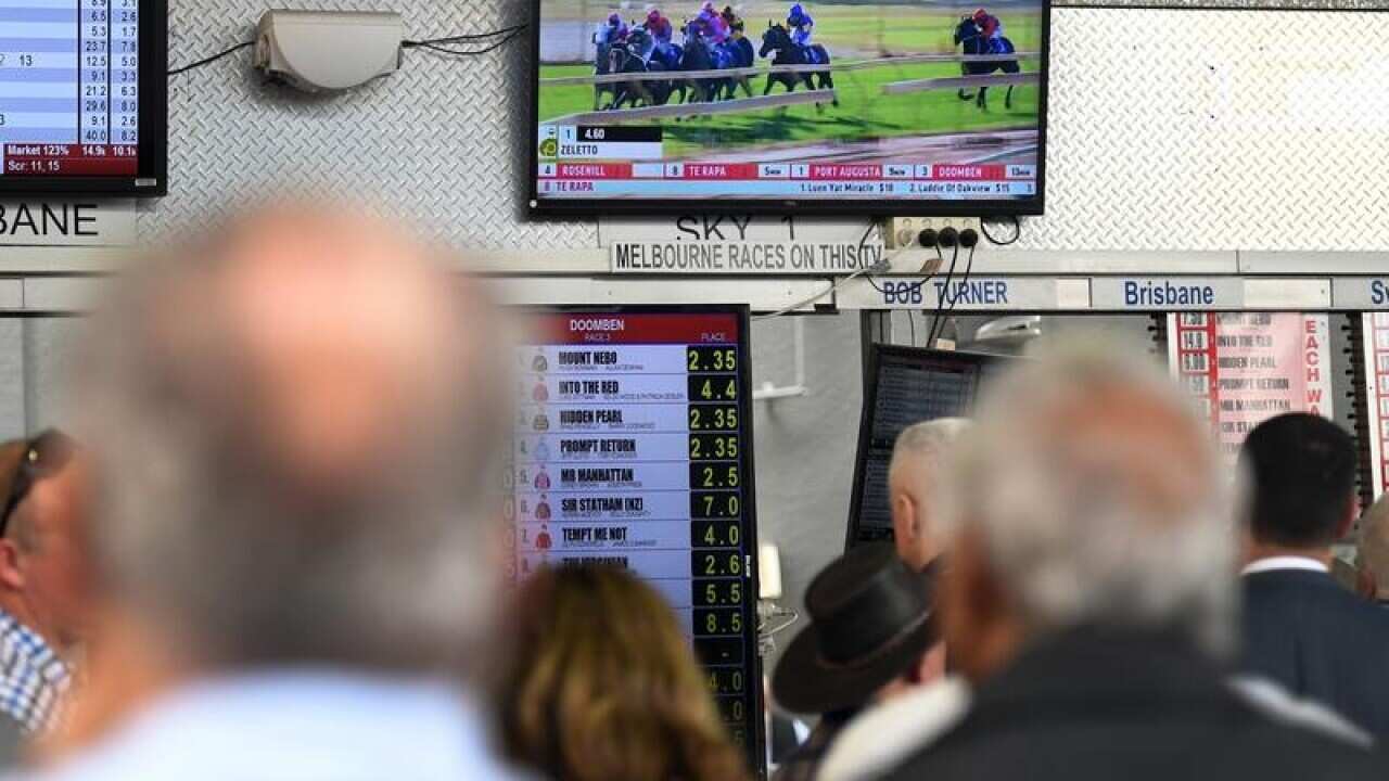Racegoer place bets during the Doomben Cup Day