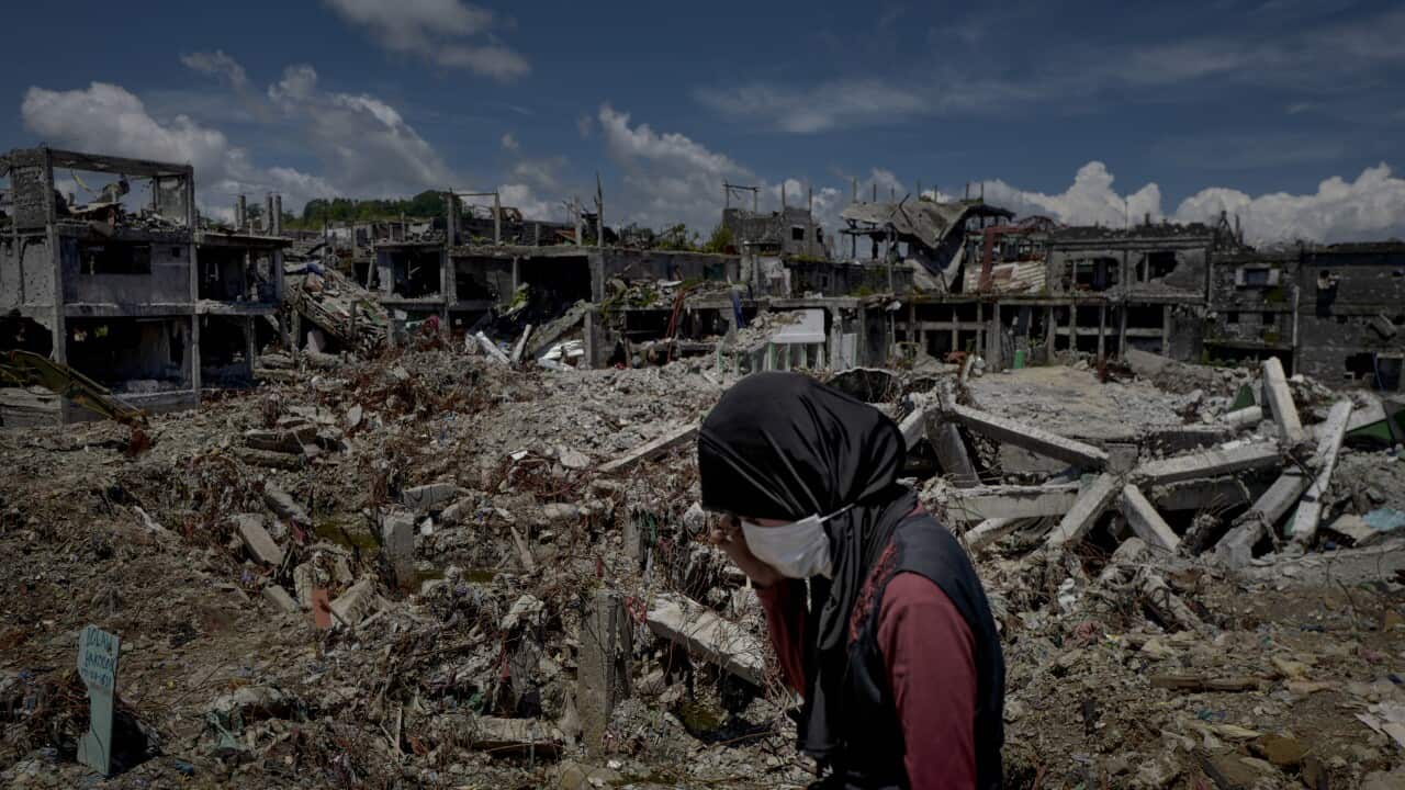 A woman standing amidst the destruction inside Marawi city on May 10, 2018 in Marawi, Philippines.