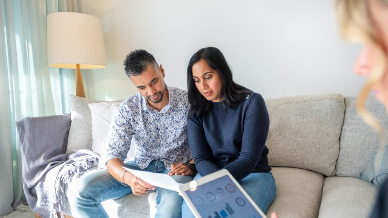 Migrant couple meeting with a real estate agent.