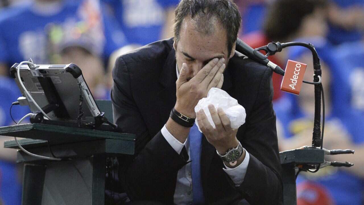 Umpire Arnaud Gabas, of France, after being hit by a ball