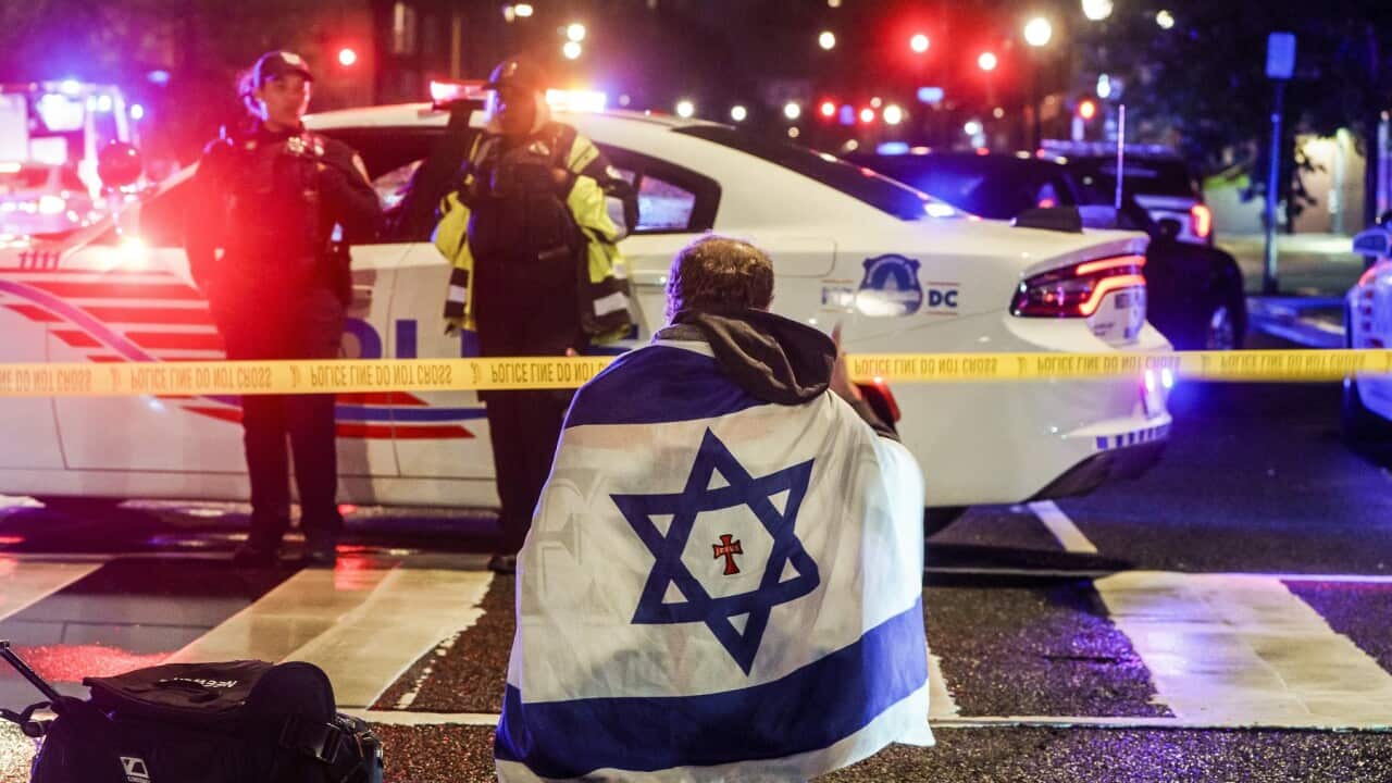 A man with an Israeli flag near the scene where two people were shot and killed (AAP)