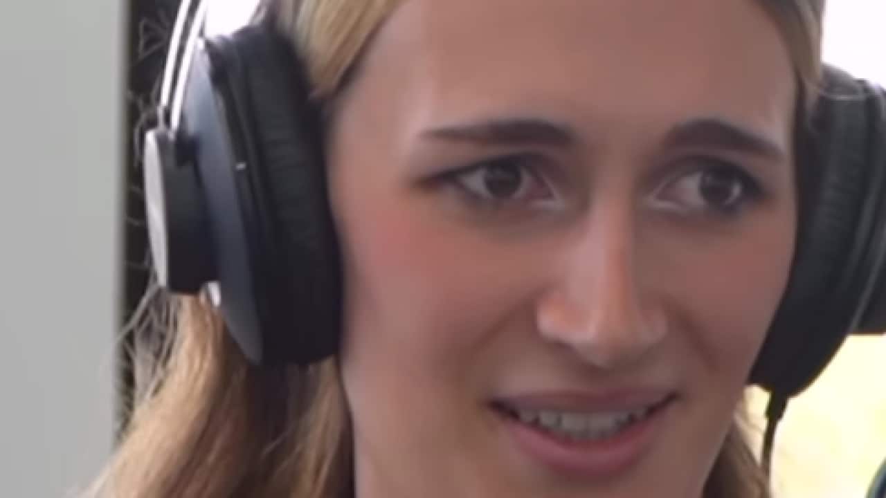 A woman smiling with headphones on