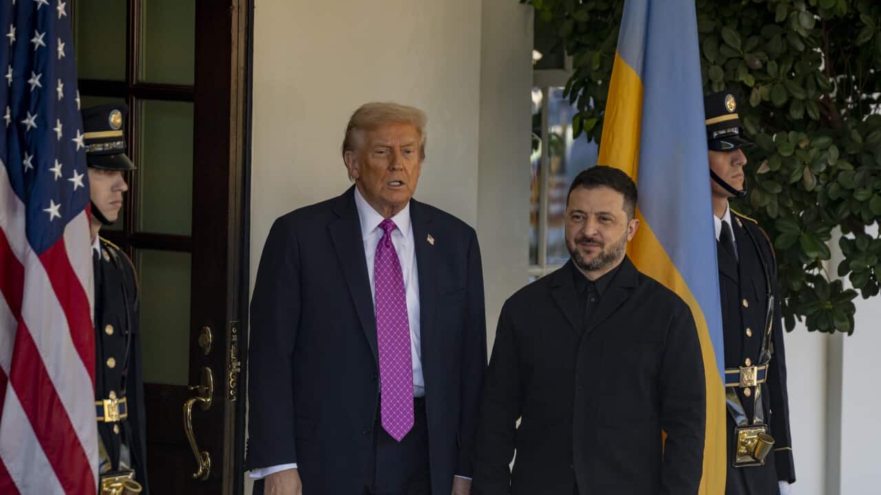 US president Donald Trump and Ukrainian President Volodymyr Zelenskyy standing outside a doorway to the White House. The US and Ukranian flags hang on a flag pole.