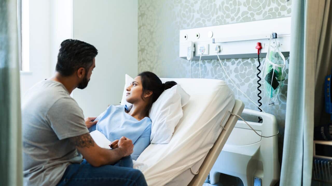 Mature man consoling sad sick woman in hospital