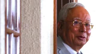 Najib Razak looking out a window or doorway.