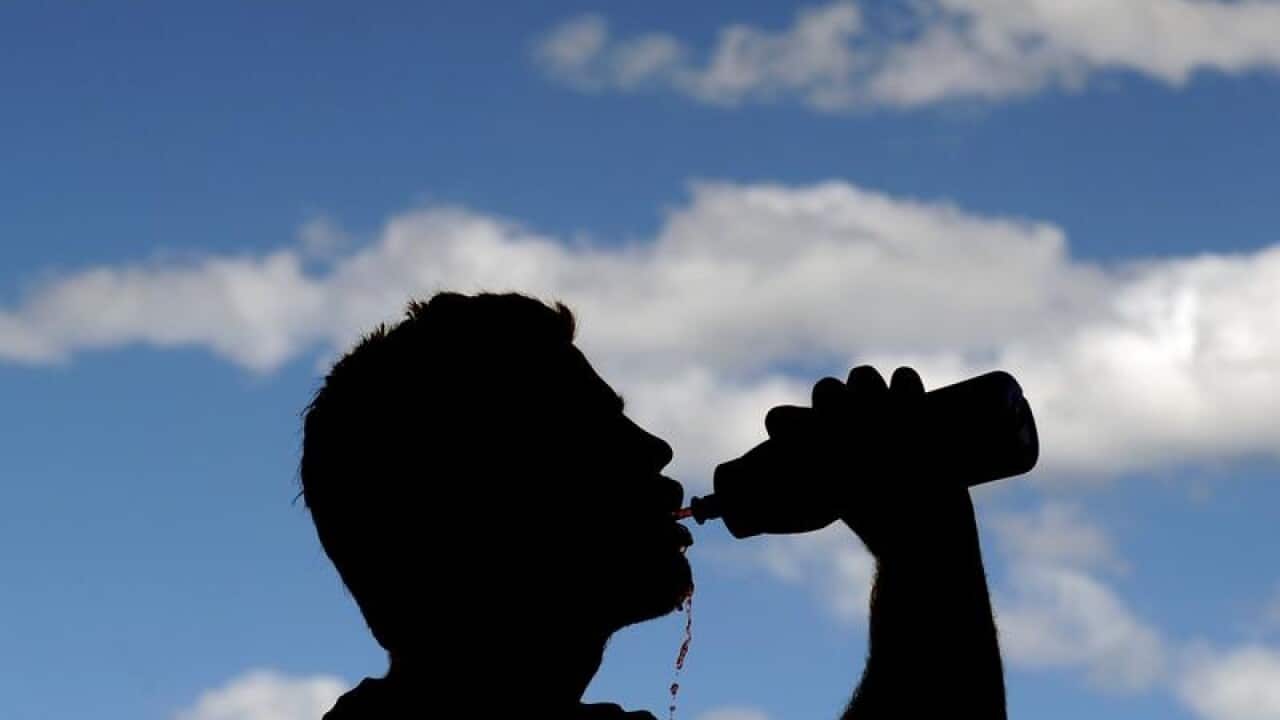 A file stock image of a silhouetted man drinking from a bottle.