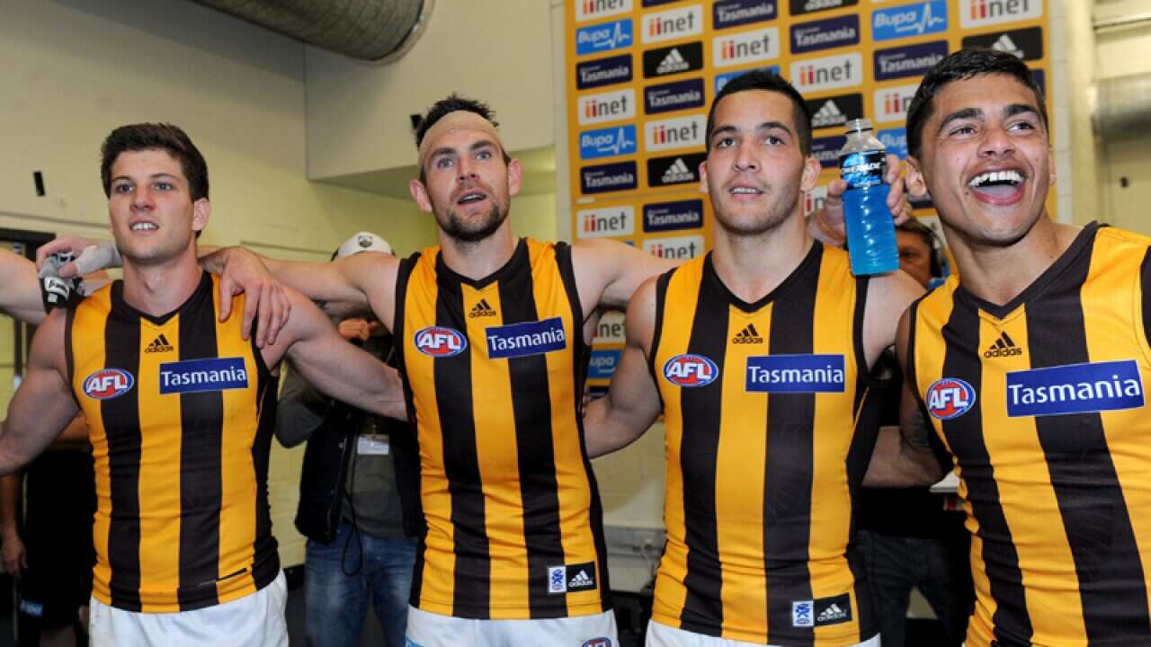 Hawthorn players sing the team song after beating North Melbourne