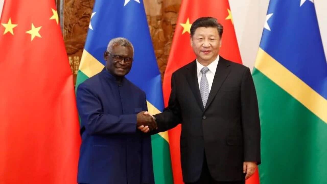 Solomon Islands' Prime Minister Manasseh Sogavare shakes hands with Chinese President Xi Jinping.