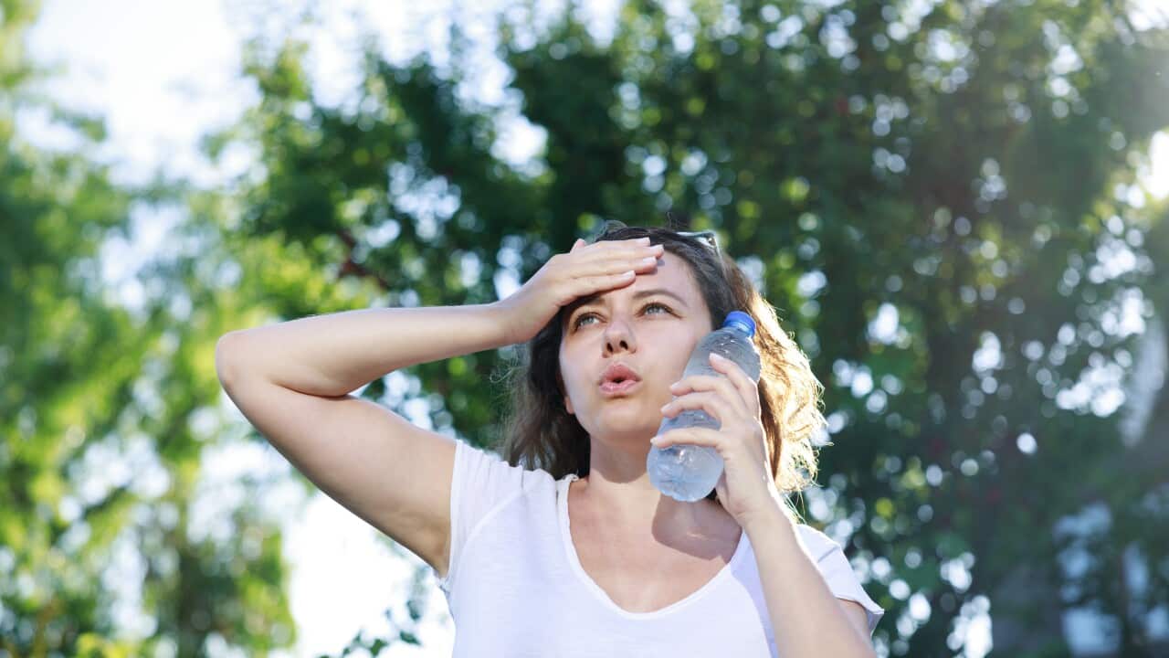 Young woman having hot flash and sweating in a warm summer day