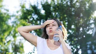 Young woman having hot flash and sweating in a warm summer day