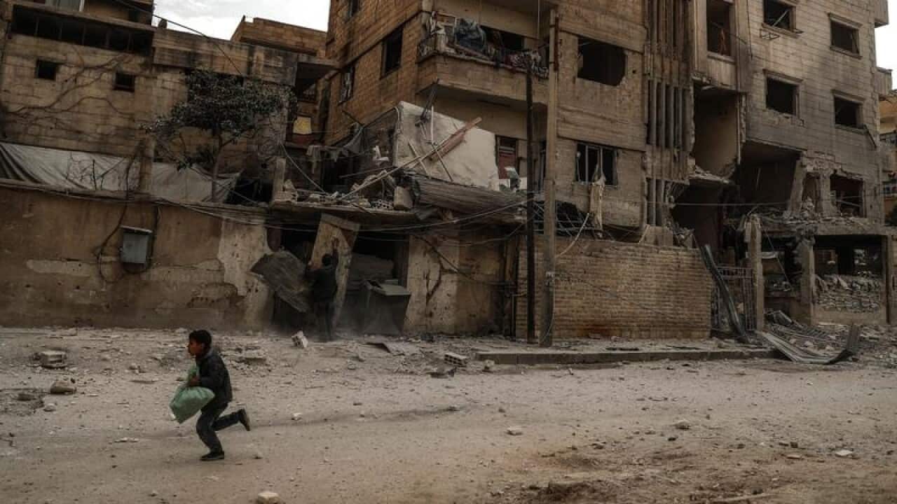 A boy runs through a bombed neighbour in Douma, eastern Ghouta.