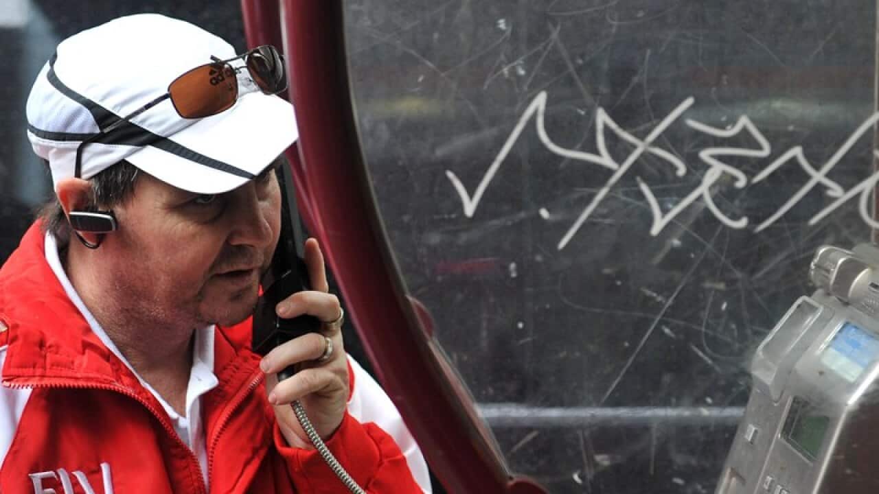 A man uses a public telephone