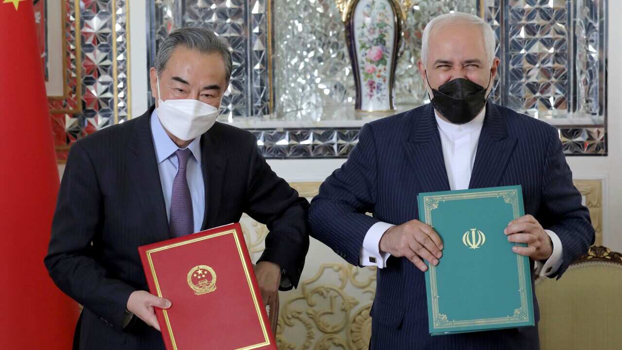 Iranian Foreign Minister Mohammad Javad Zarif, right, and his Chinese counterpart Wang Yi, pose for photos after the ceremony of signing documents, in Tehran, Iran, Saturday, March 27