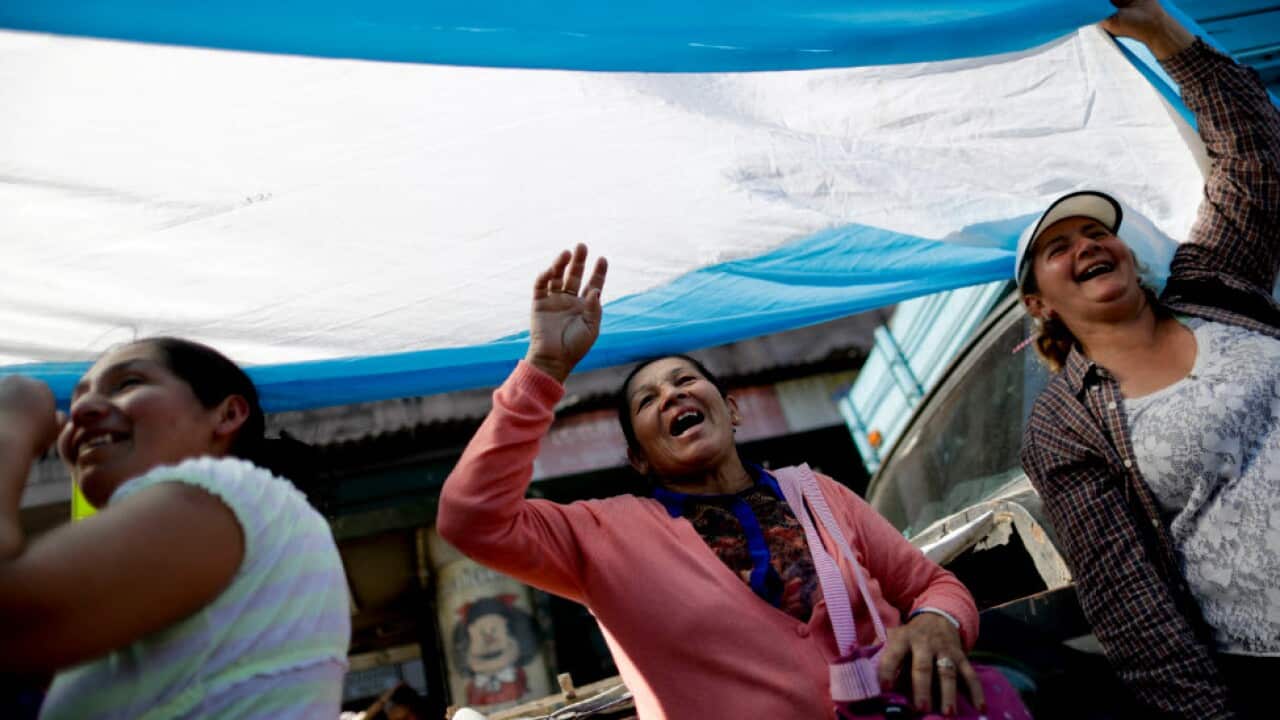 Demonstrators hold up an Argentina national flag in front of the National Congress during a protest.
