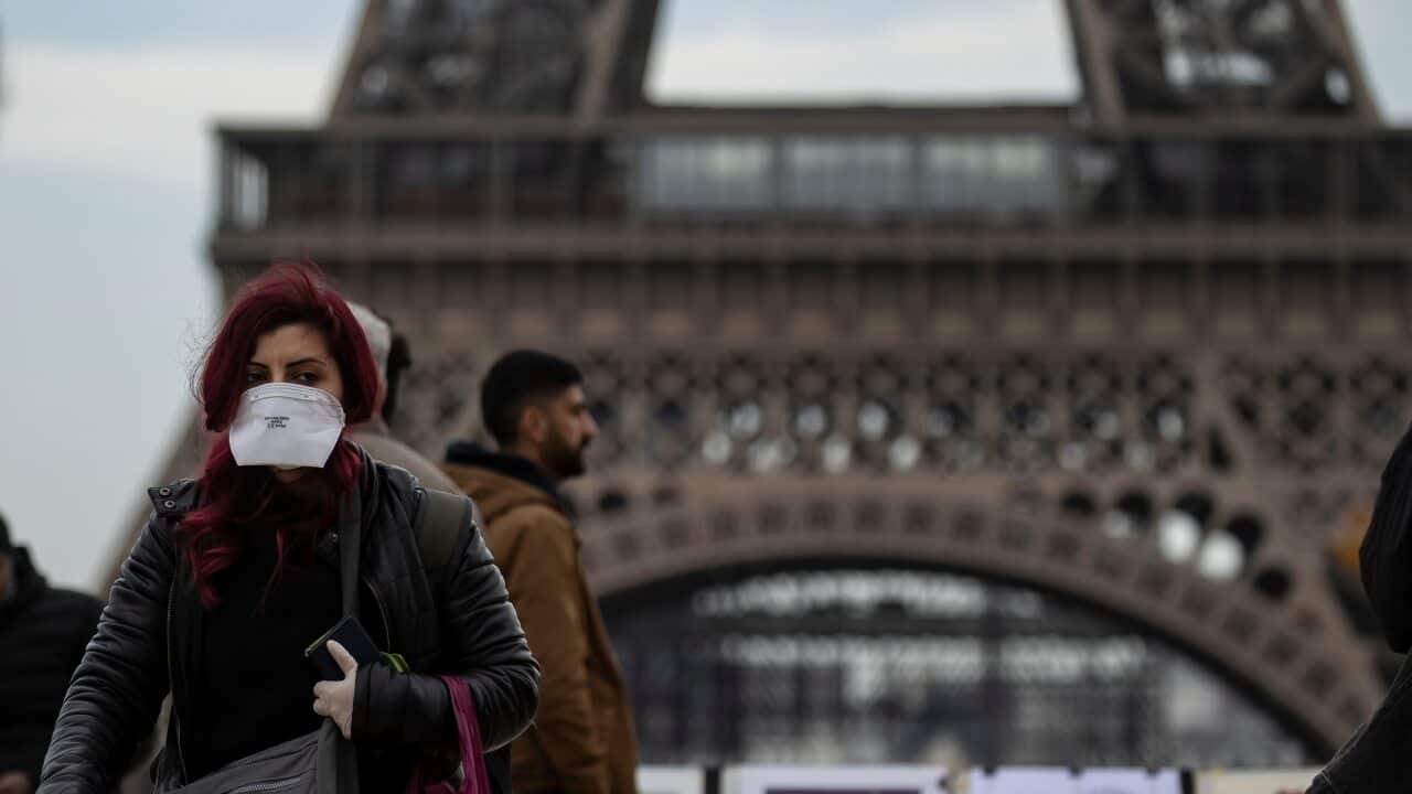 A woman wears a protective face mask near the Eiffel Tower, in Paris, France.