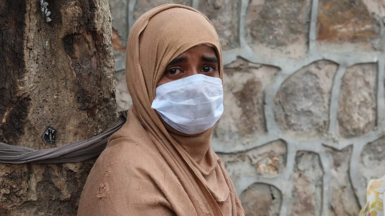 A Rohingya woman reacts after a fire damaged her shanti at a refugee camp in New Delhi, India