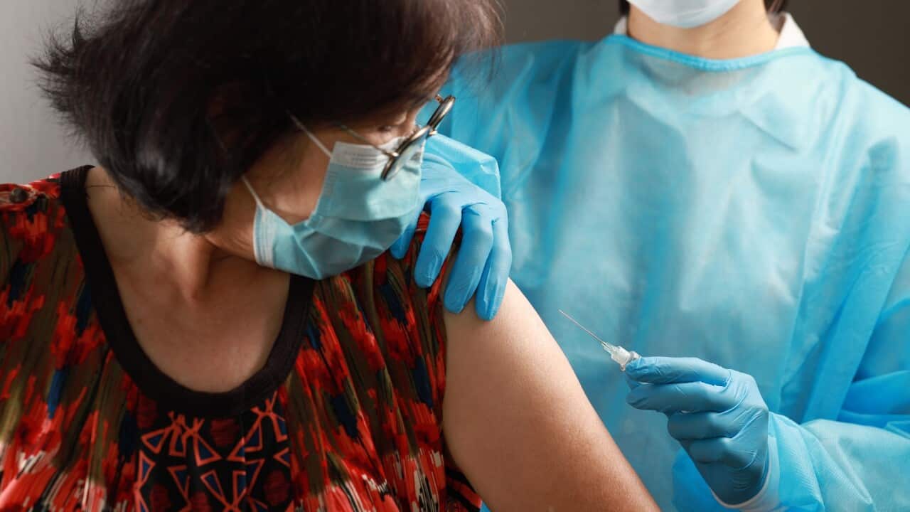 Syringe needle and vaccine in the hands of a nurse.