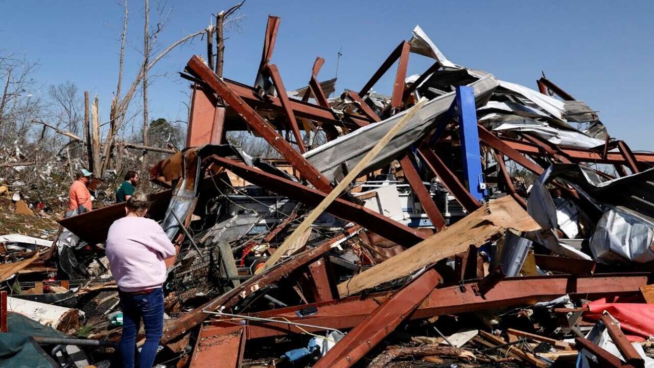Family members search for belongings in the damage after a tornado passed through their Alabama town (AAP).jpg
