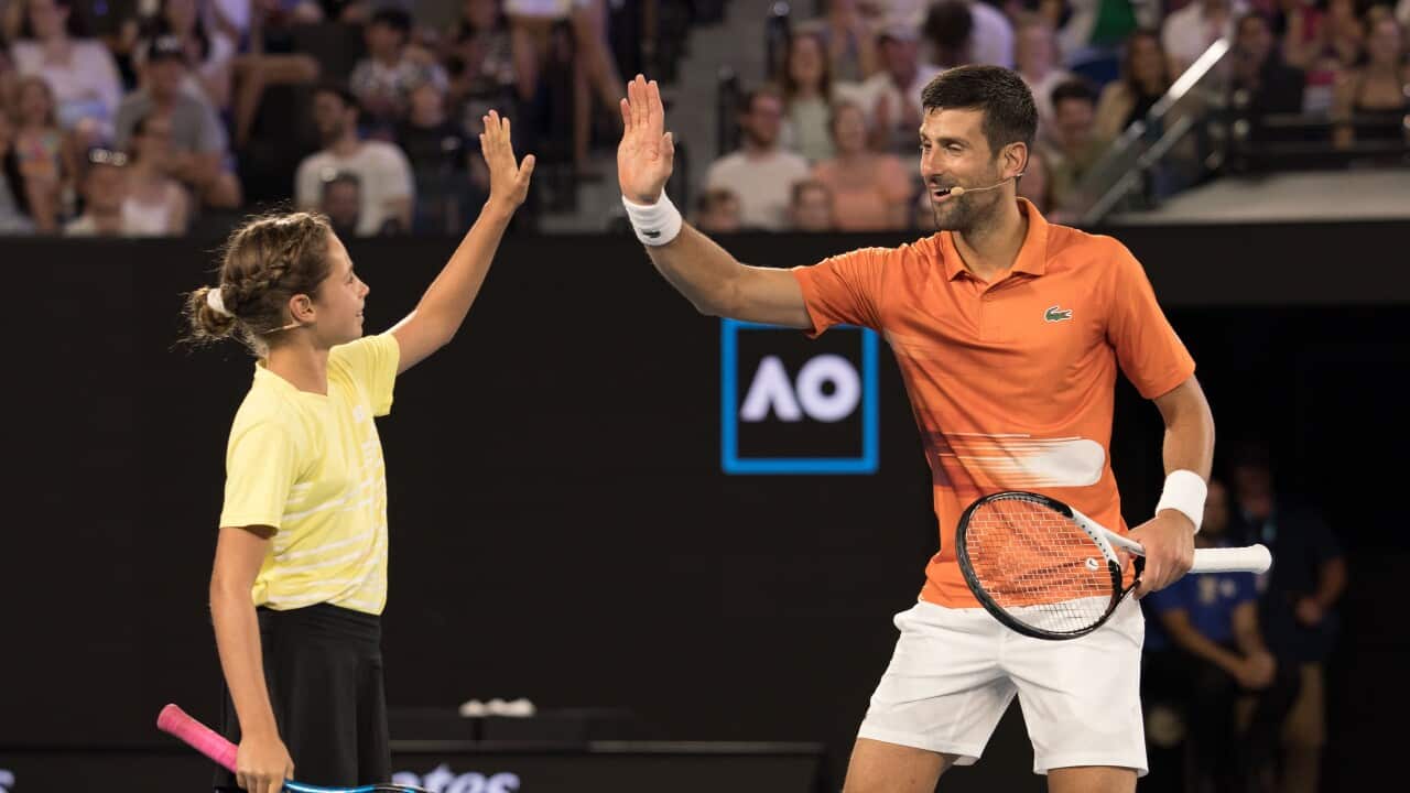 Novak Djokovic celebrates with 10 year old Ana Maric during an exhibition charity match against Nick Kyrgios at Rod Laver Arena
