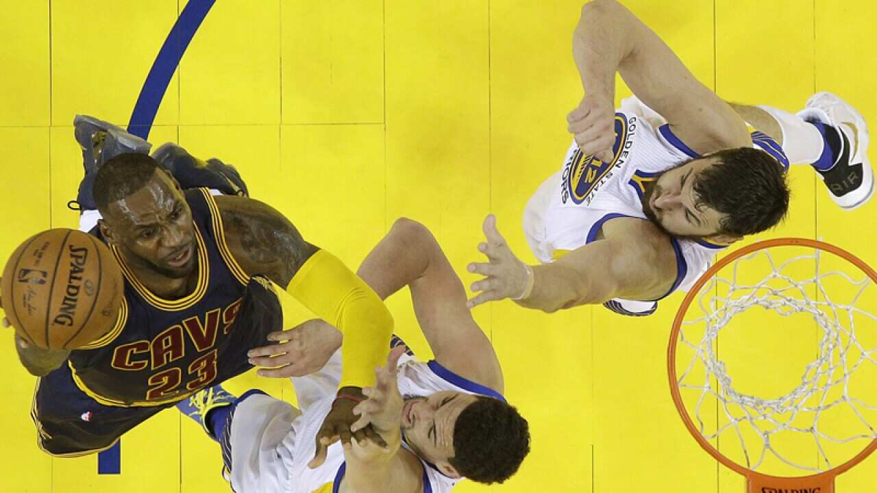 Golden State's Andrew Bogut (R) defends Cavaliers' LeBron James