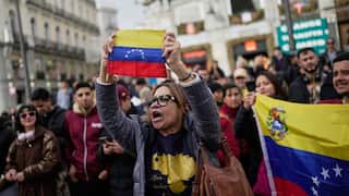 A woman holding the Venezuelan flag up in a march