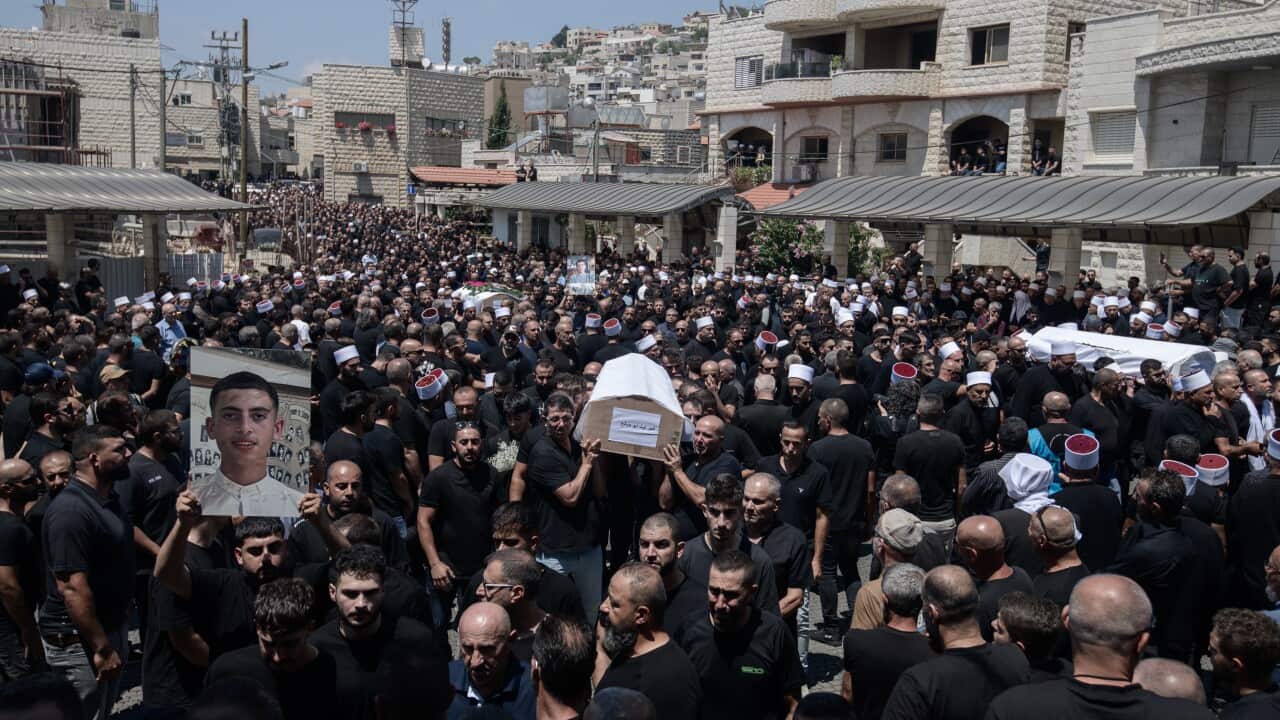 Israeli Druze mourners at the funeral of the 12 children and teens killed in a Hezbollah rocket strike (AAP)