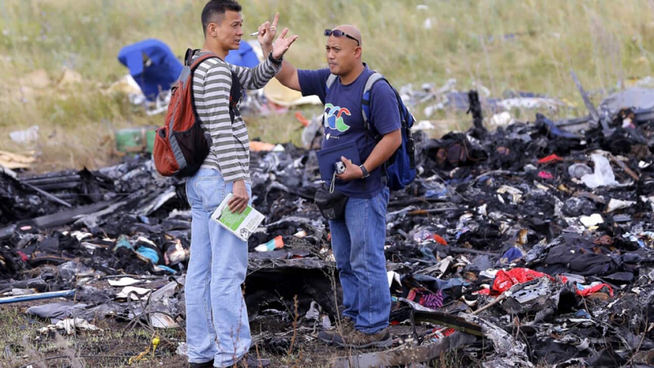 Malaysian investigators look through debris at MH17 crash site.