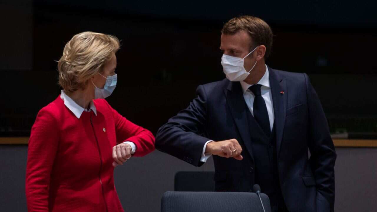 European Commission President Ursula von der Leyen (L) greets French President Emmanuel Macron with an elbow bump during an EU summit