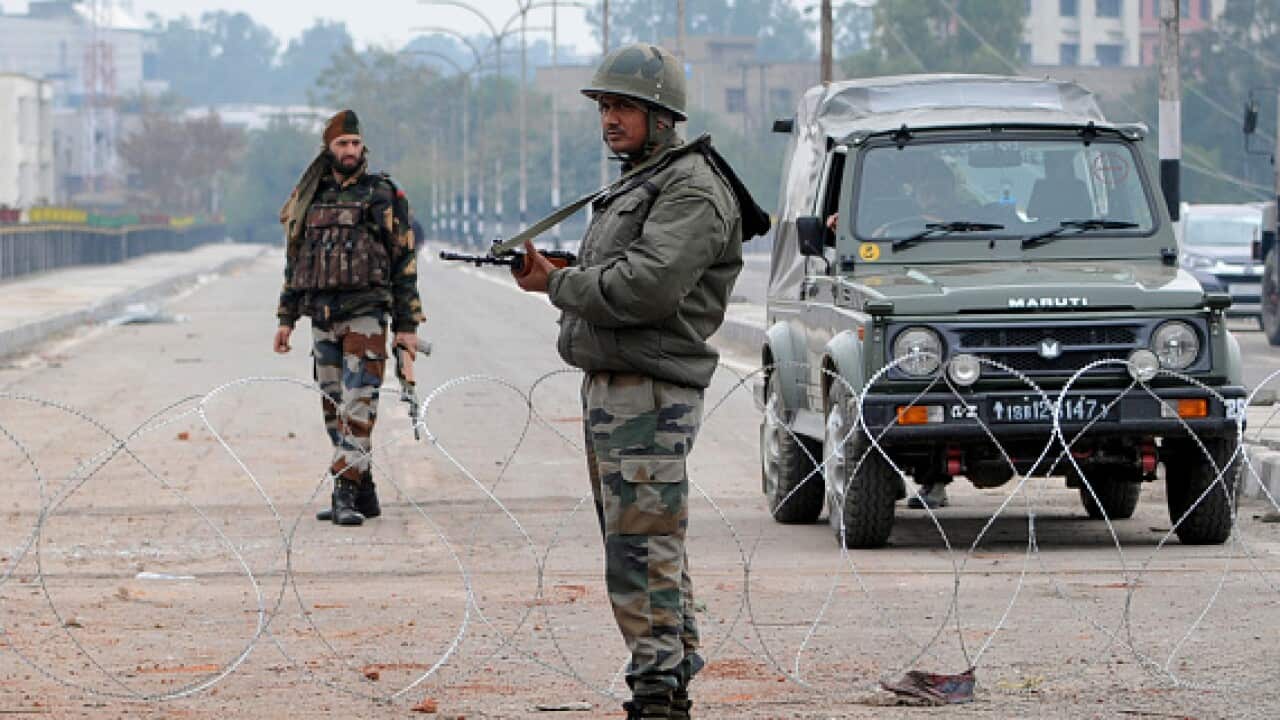 Army personnel stand guard during a curfew on 17 February in Jammu, India. 