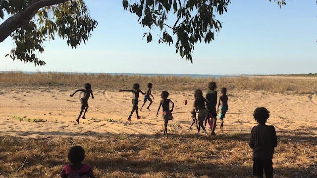 Children play football on the beach