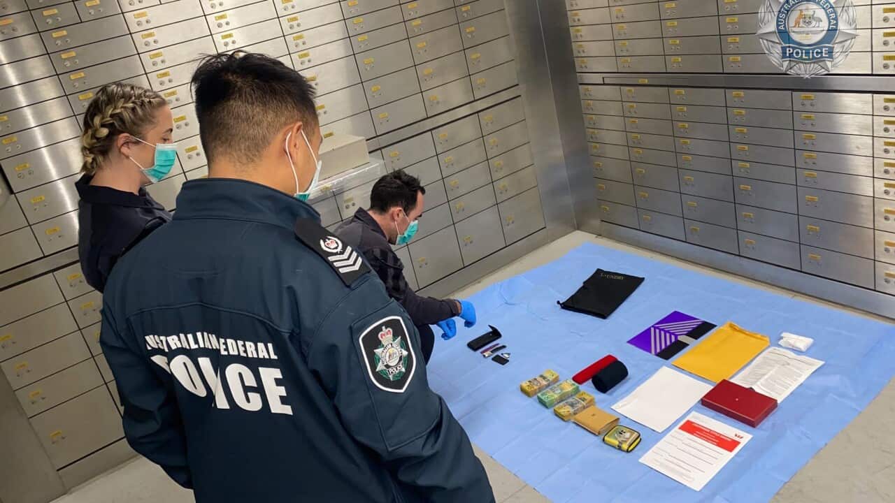 Australian Federal Police with their seized items as part of investigation