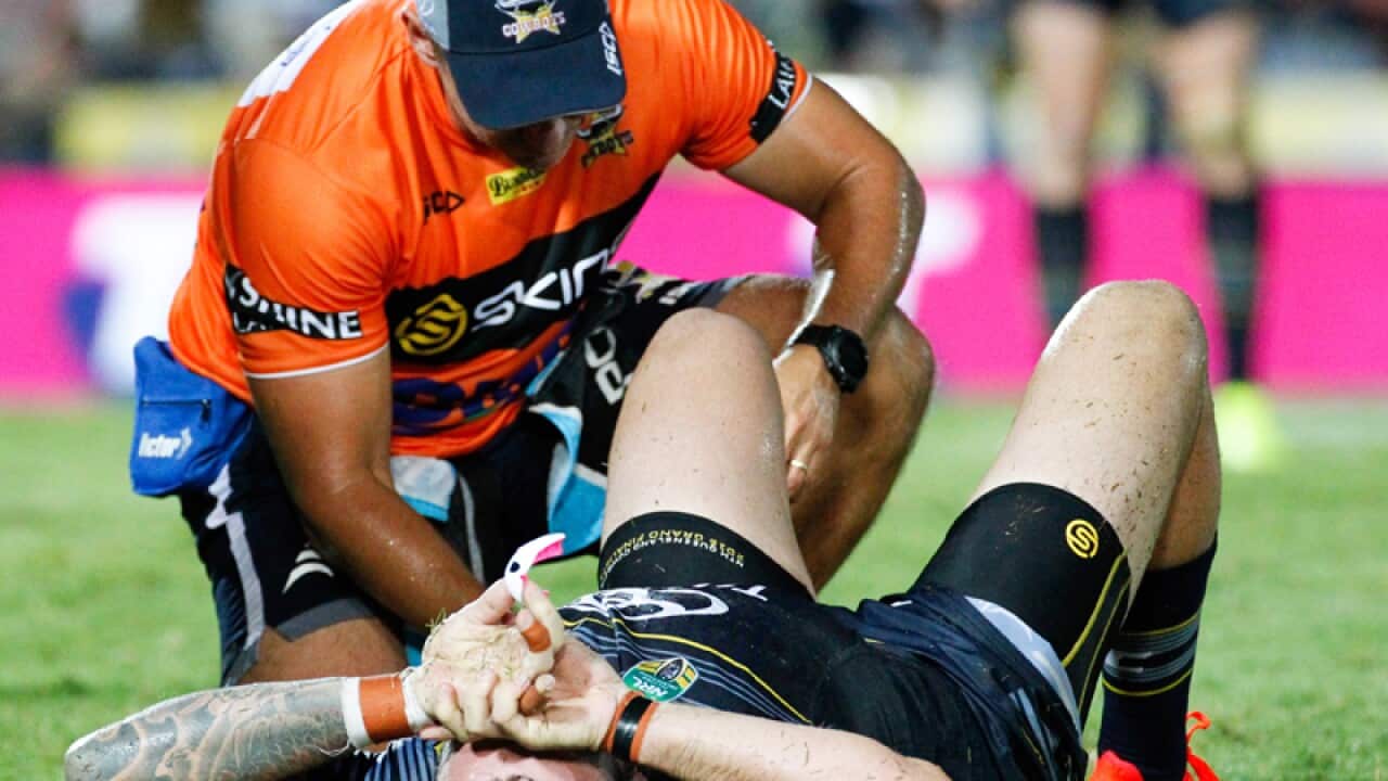 Cowboys Kyle Feldt is attended to by head trainer Steve Sartori