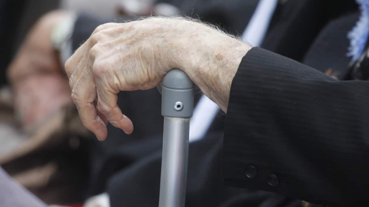 An elderly man rests his hand on a walking stick during a visit to the Australian War Memorial in Canberra, Wednesday, April 3, 2013