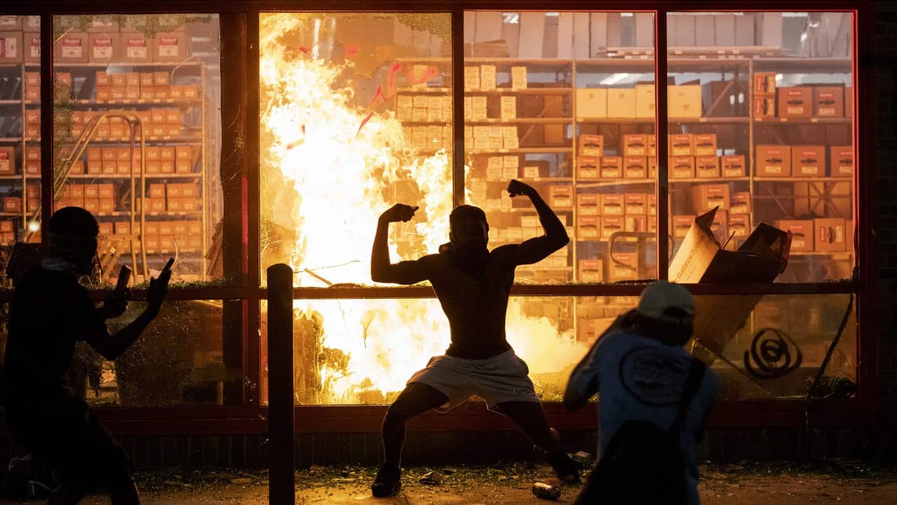 A fire burns at an AutoZone store in Minneapolis as people riot over the death of George Floyd. 