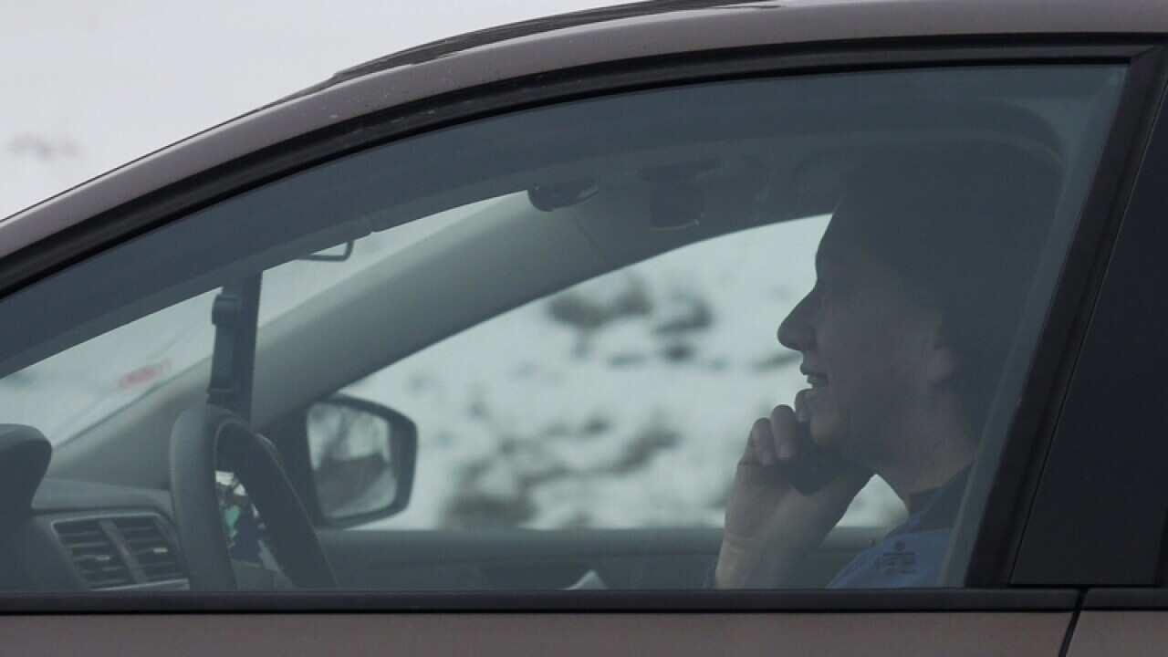 A motorist talks on a mobile phone while driving