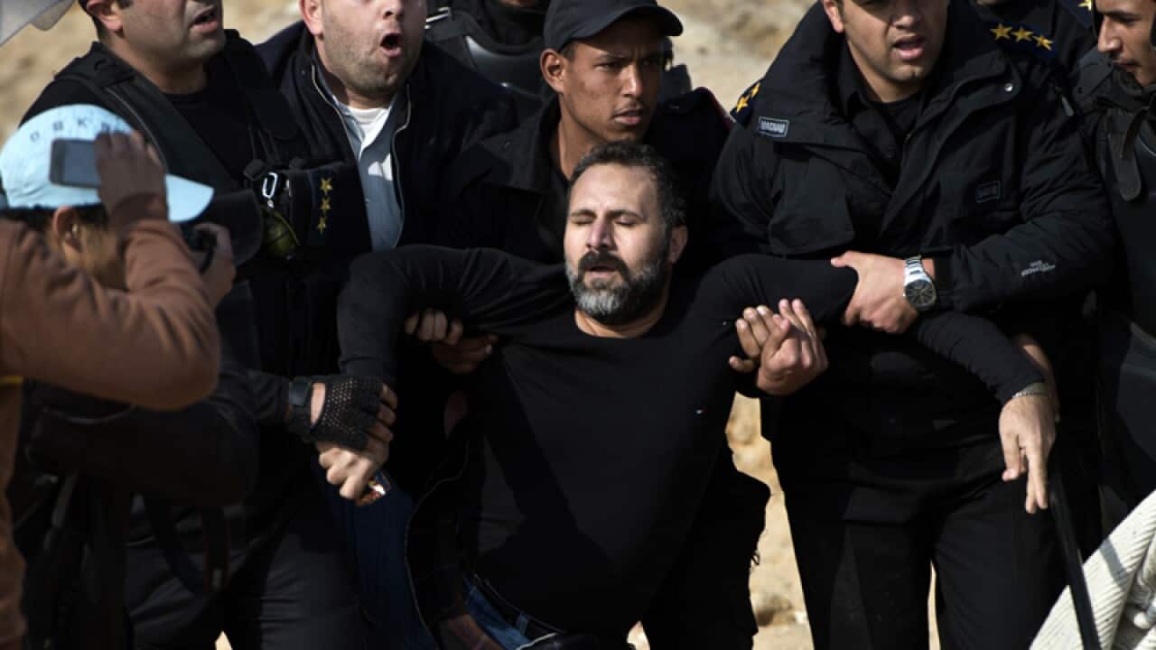 Egyptian policemen arrest a supporter of Mohamed Morsi
