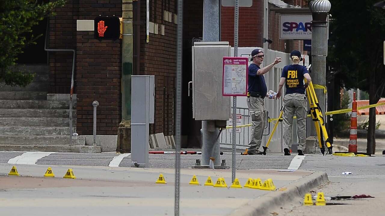 FBI investigators look at evidence on Lamar Street in front of The Dallas Police Headquarters building (EPA/RALPH LAUER)